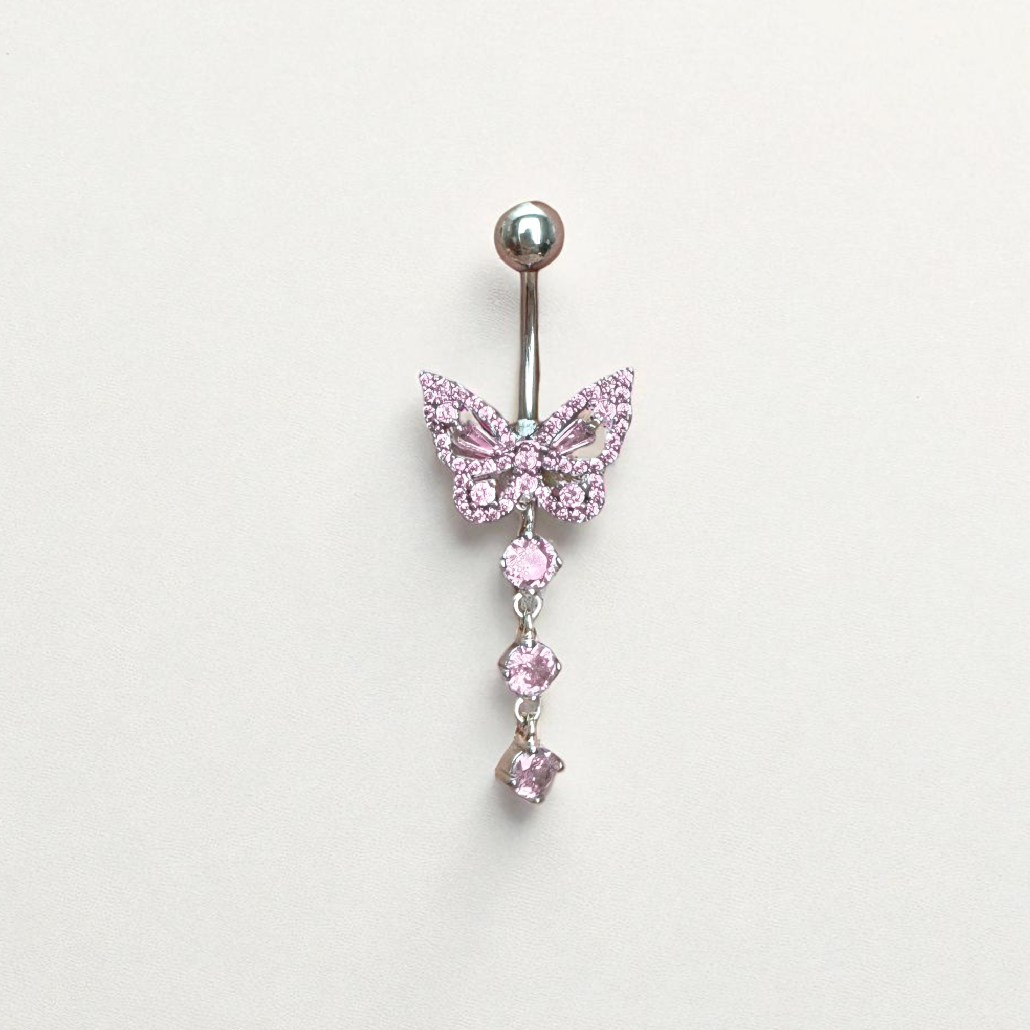 Butterfly-shaped belly button ring with pink gemstones on a light gray background