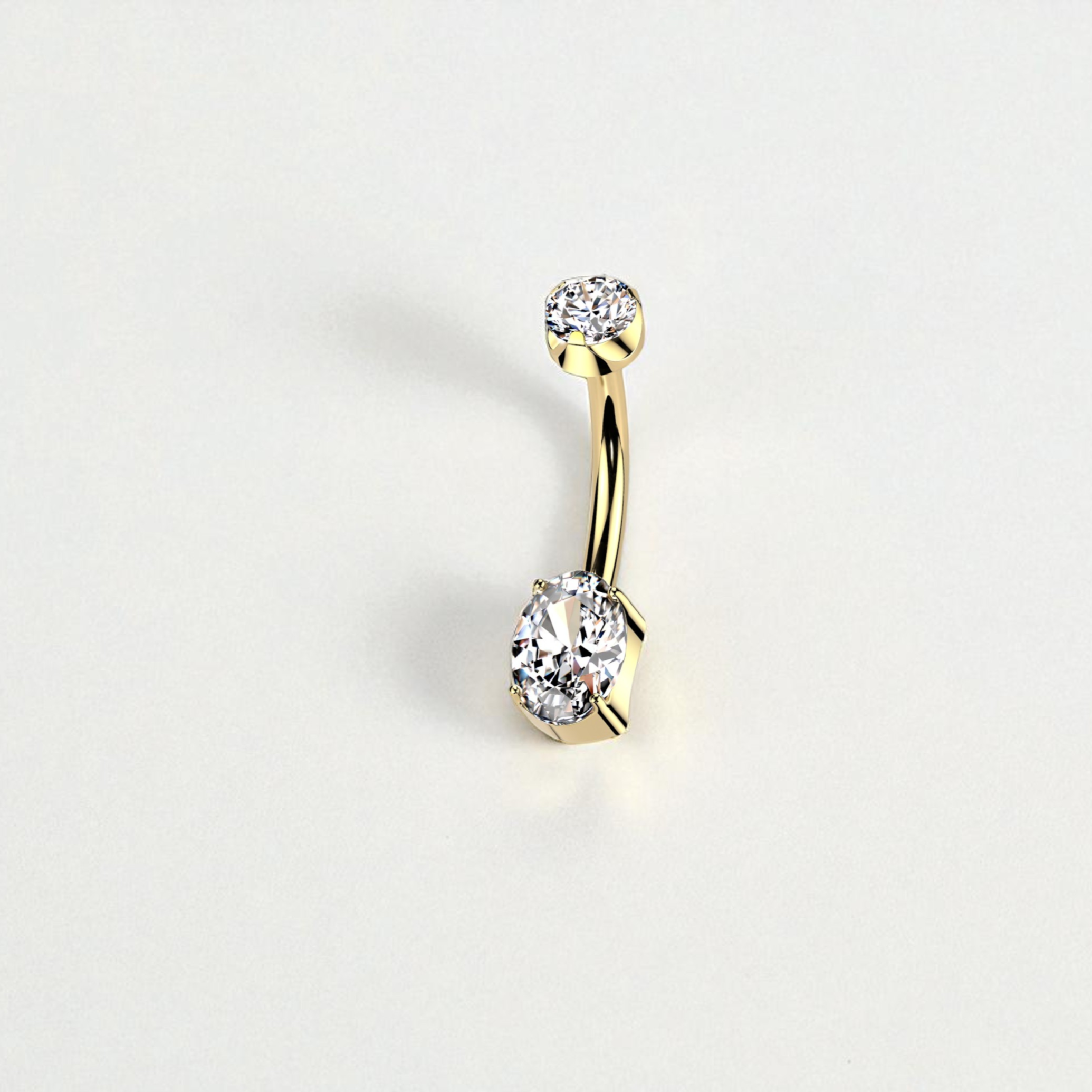 Gold belly button ring with clear gemstones on a light gray background