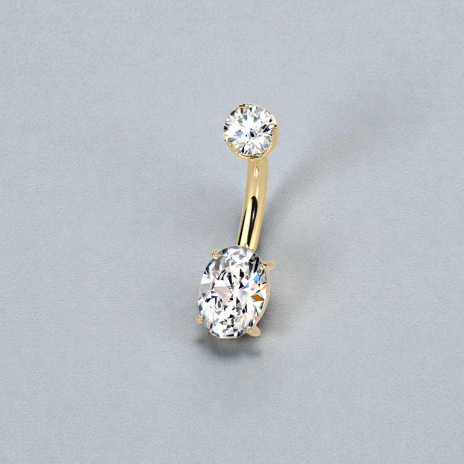 Gold belly button ring with clear gemstones on a gray background