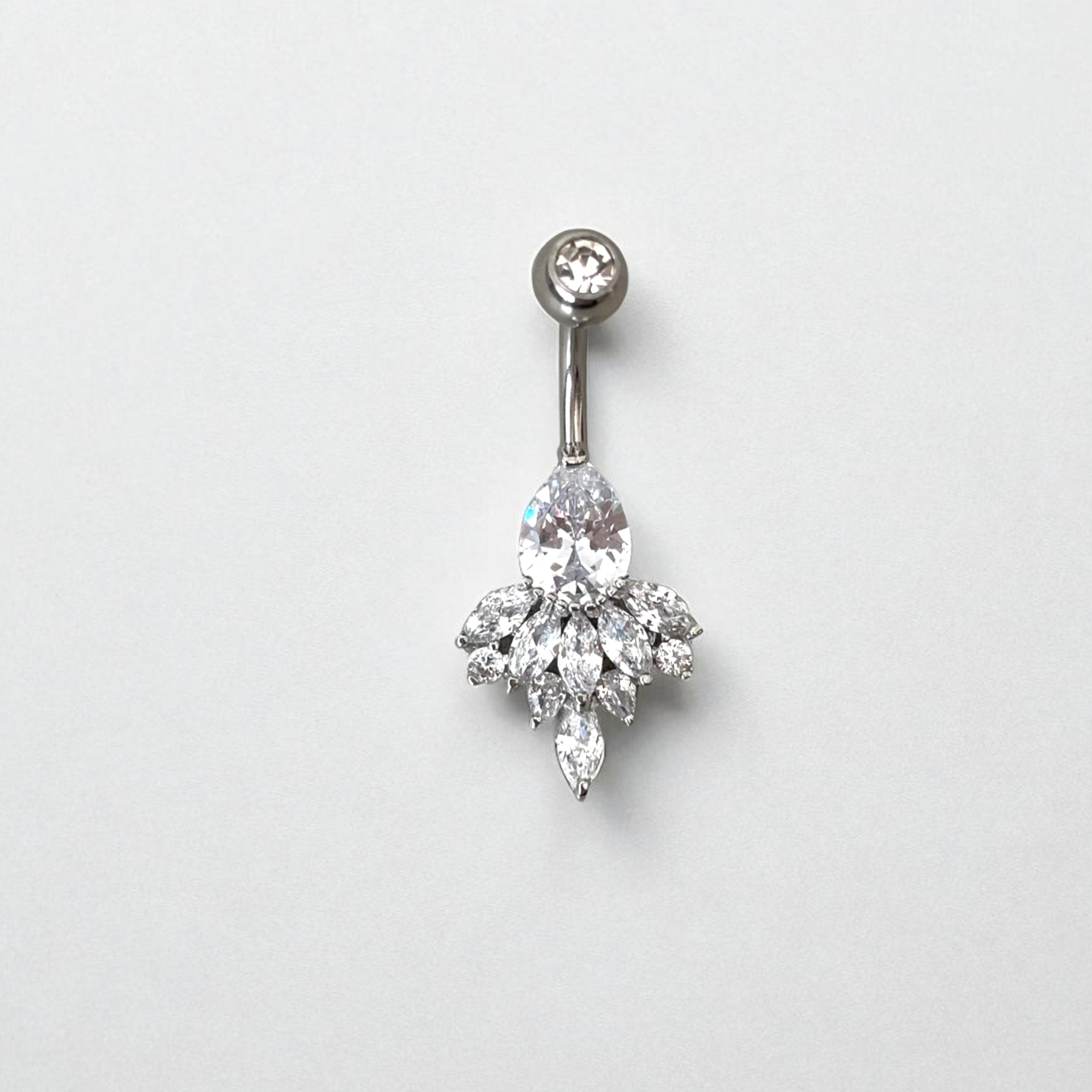 Belly button ring with a clear gemstone on a light gray background
