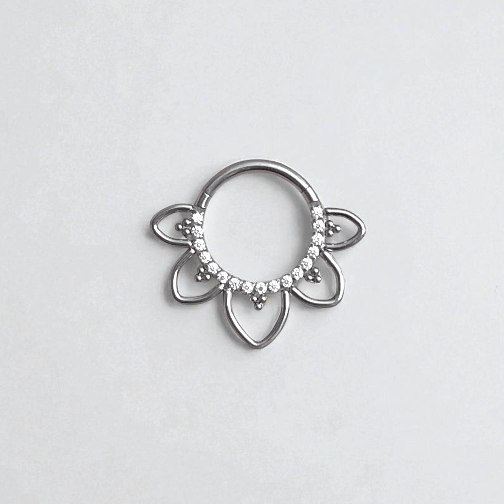 Silver fan shaped daith earring with embedded CZ crystals on a light gray background