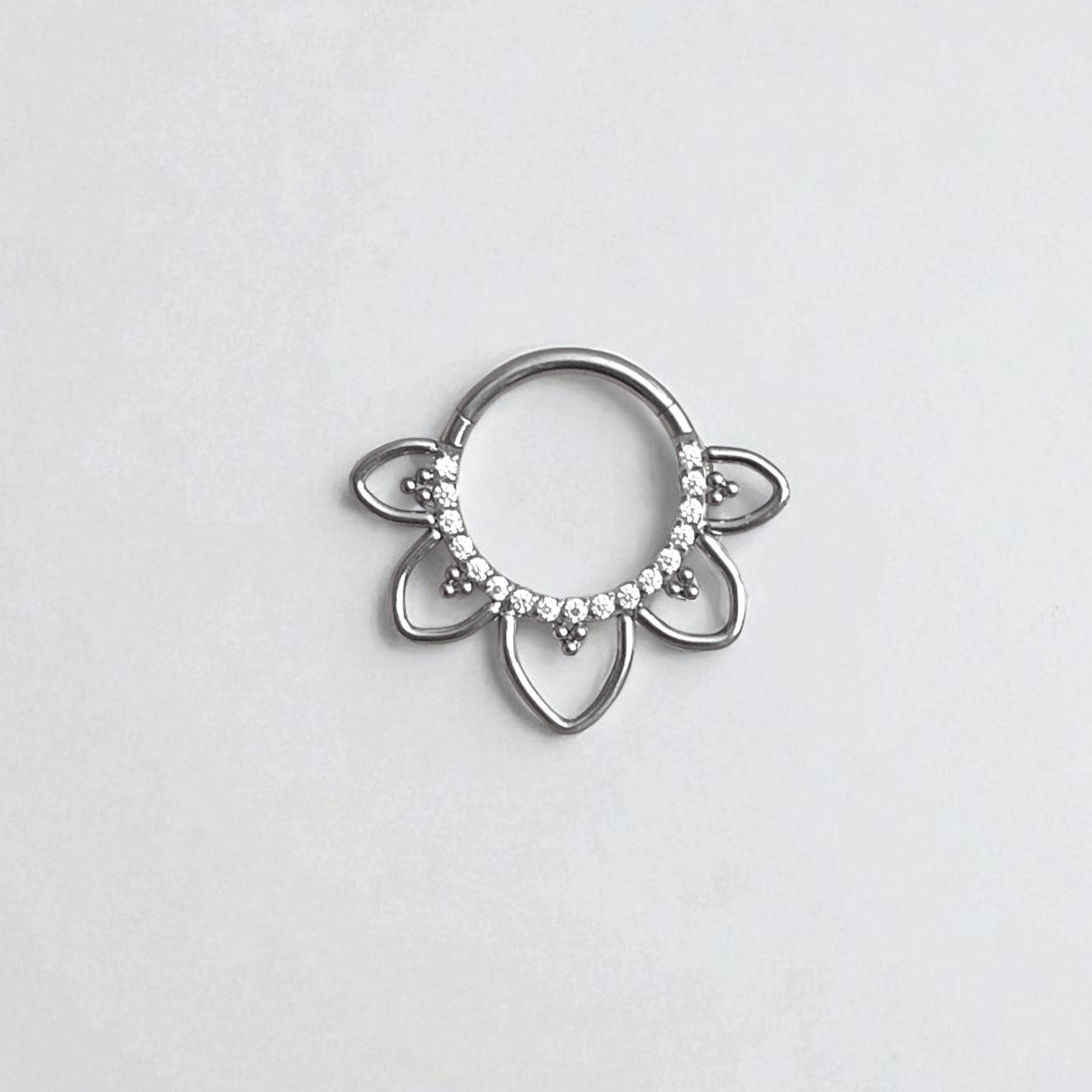 Silver fan shaped septum ring with embedded CZ crystals on a light gray background