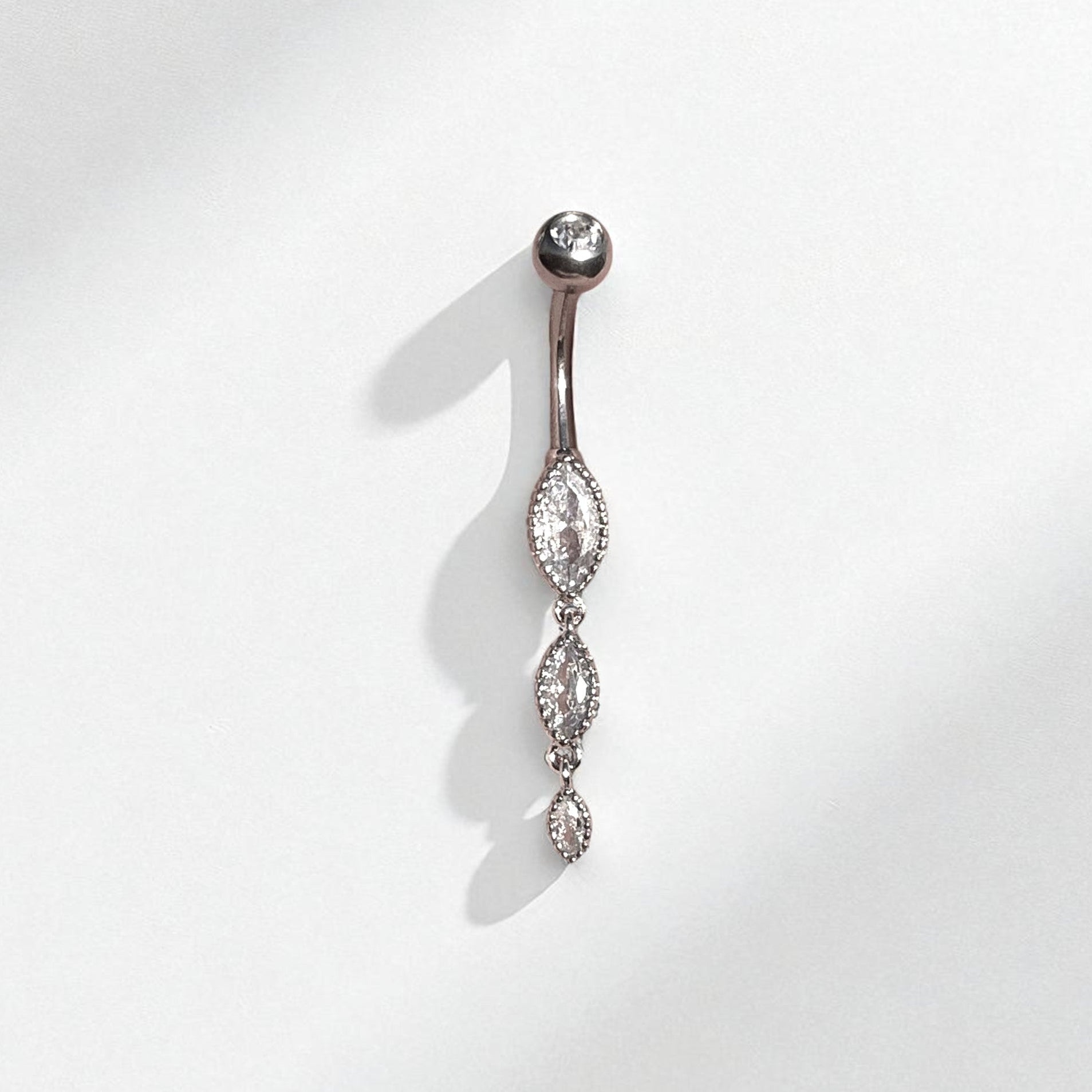Silver belly button ring with marquise gemstones on a white background