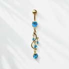 Gold belly button ring with blue gemstones on a white background