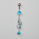 Belly button ring with blue gemstones on a gray background