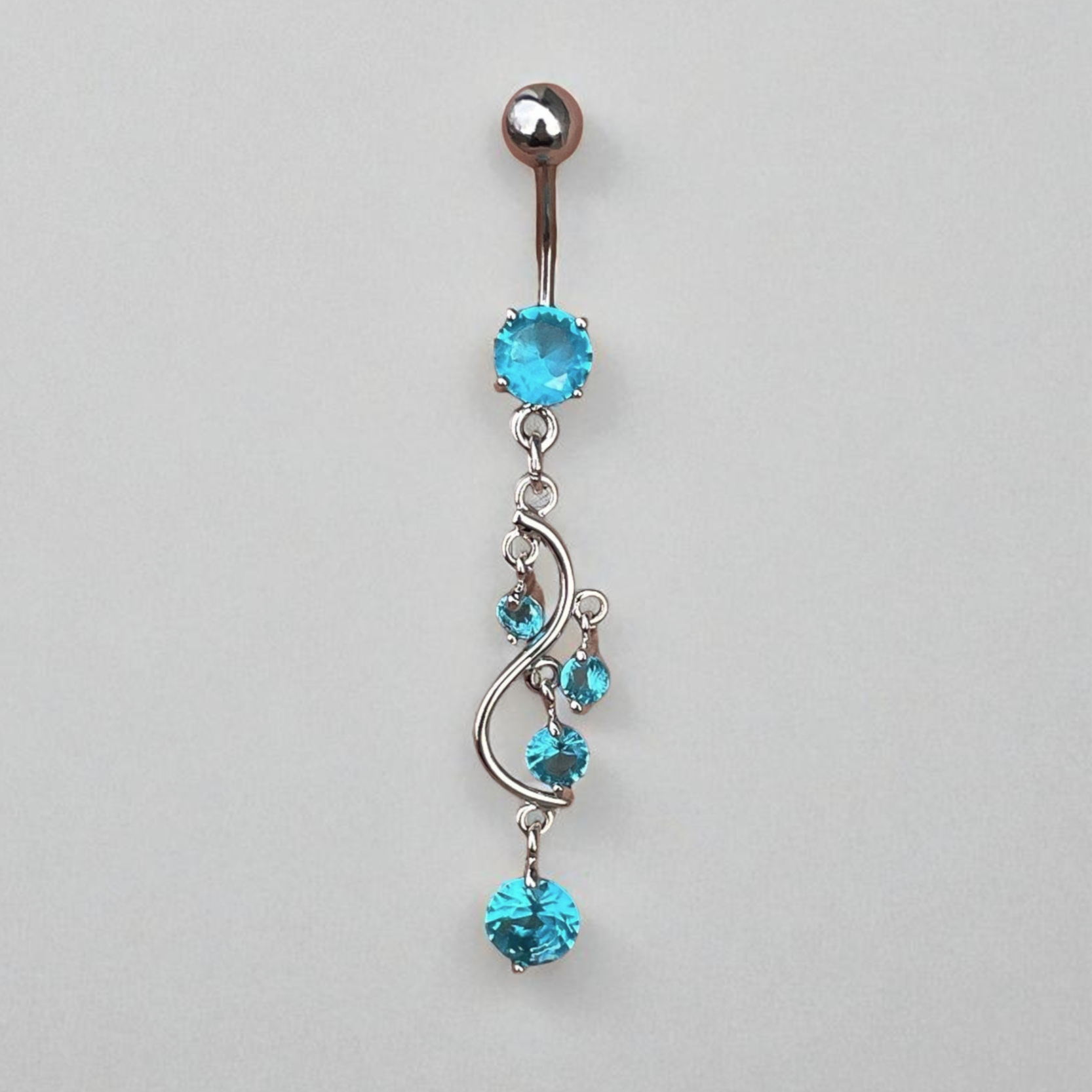 Belly button ring with blue gemstones on a gray background