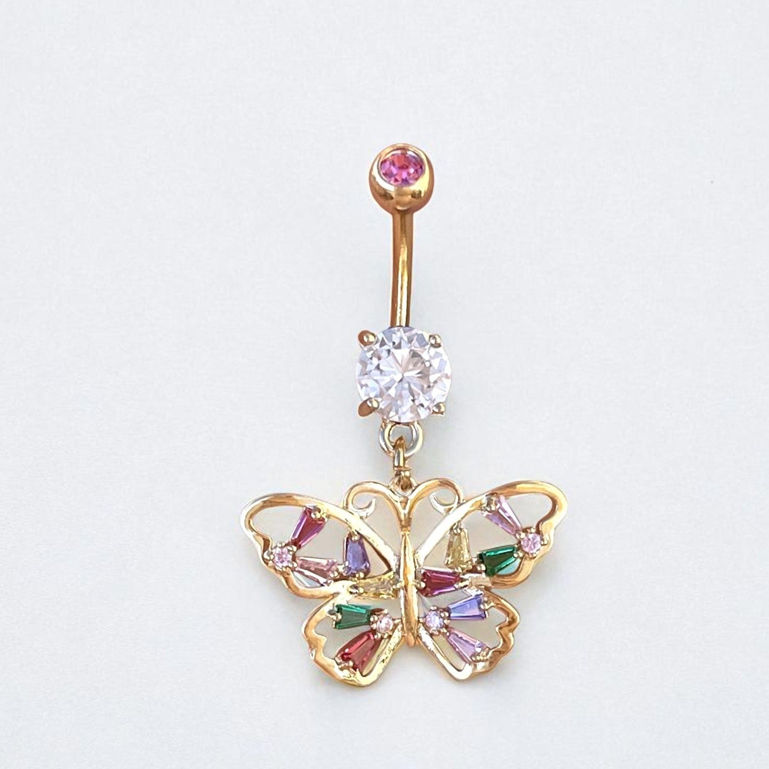 Butterfly-shaped belly button ring with gemstones on a light gray background