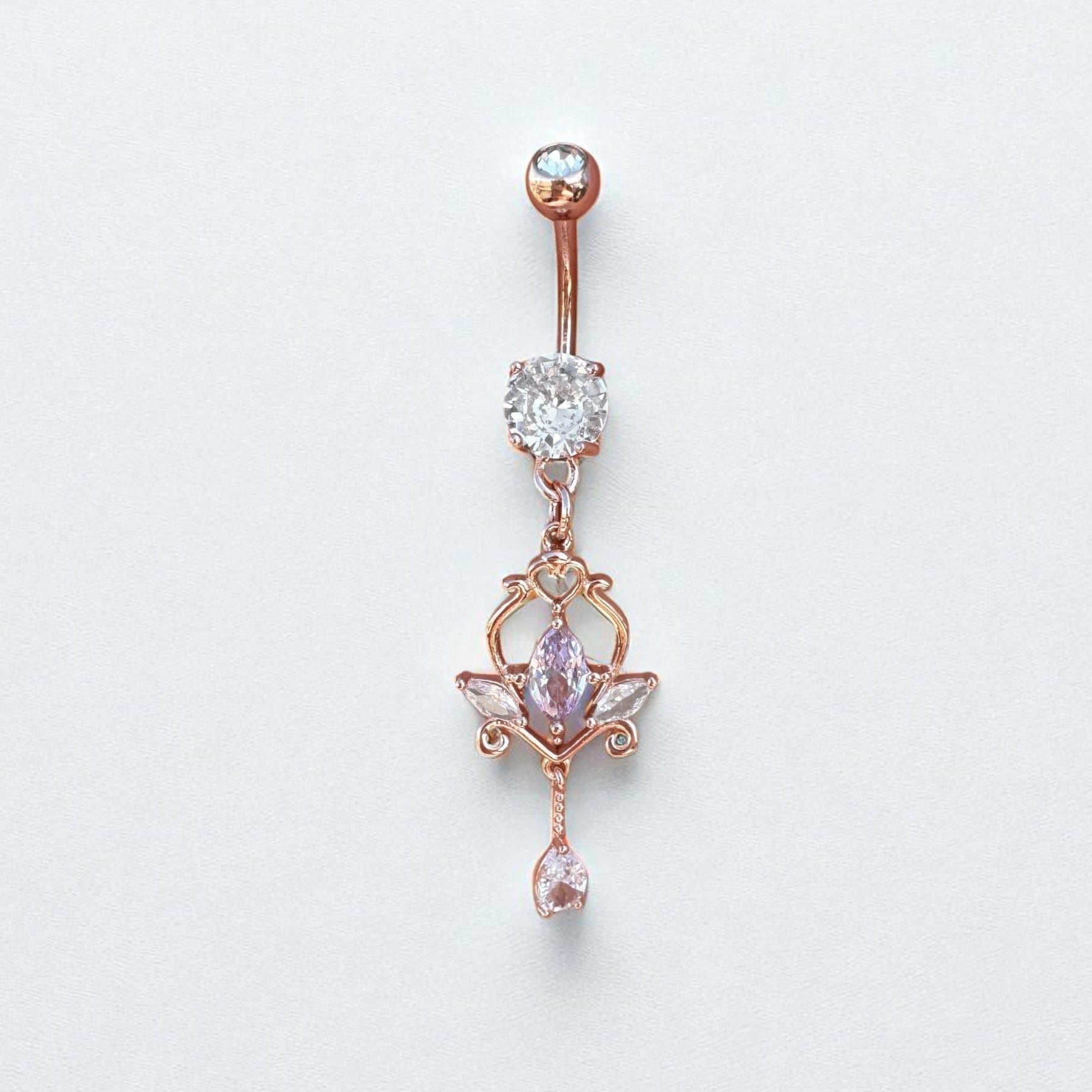 Rose gold belly button ring with gemstones on a light gray background