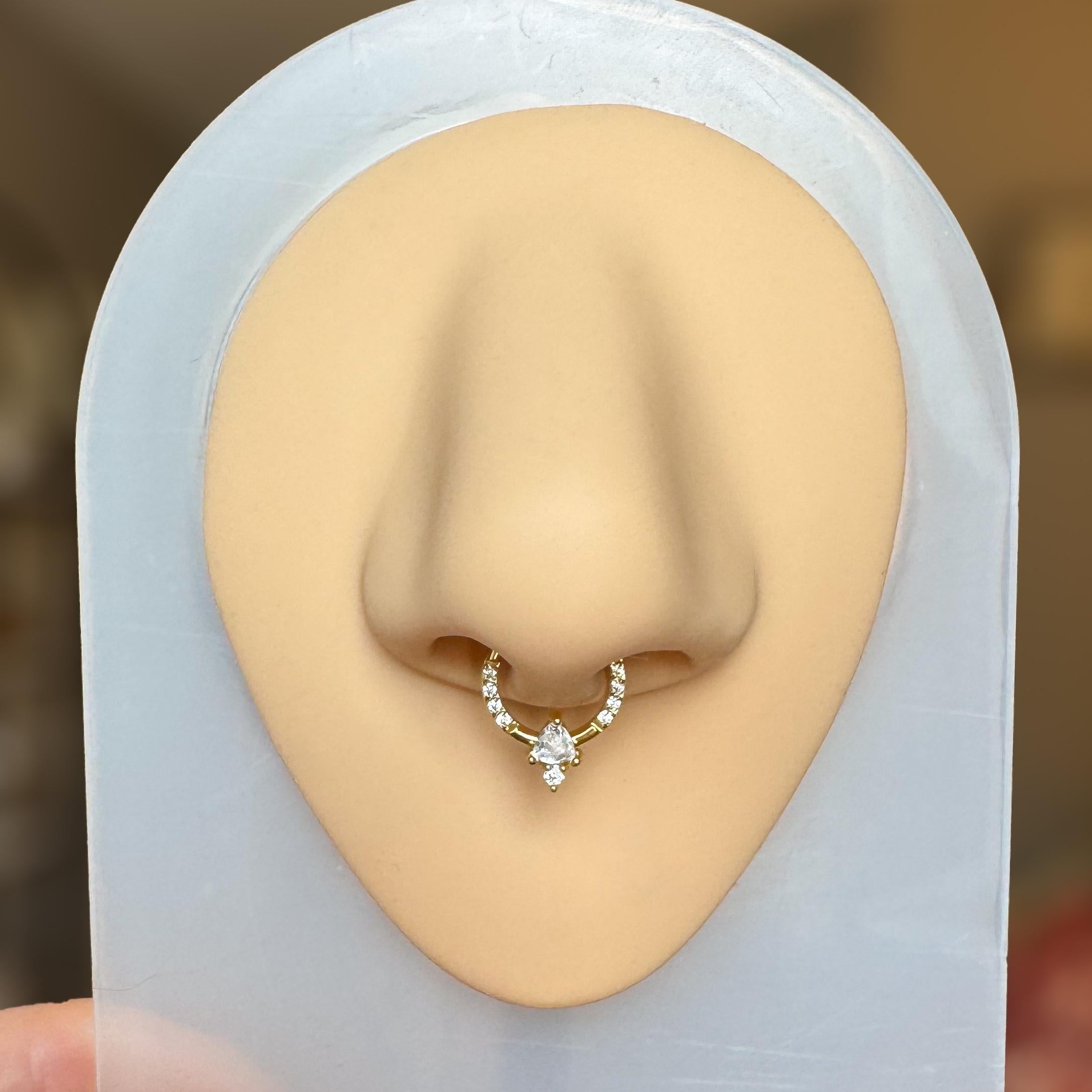 Elara Body Jewelry gold septum ring with pavé CZ stones and a central triangular and round CZ gem.