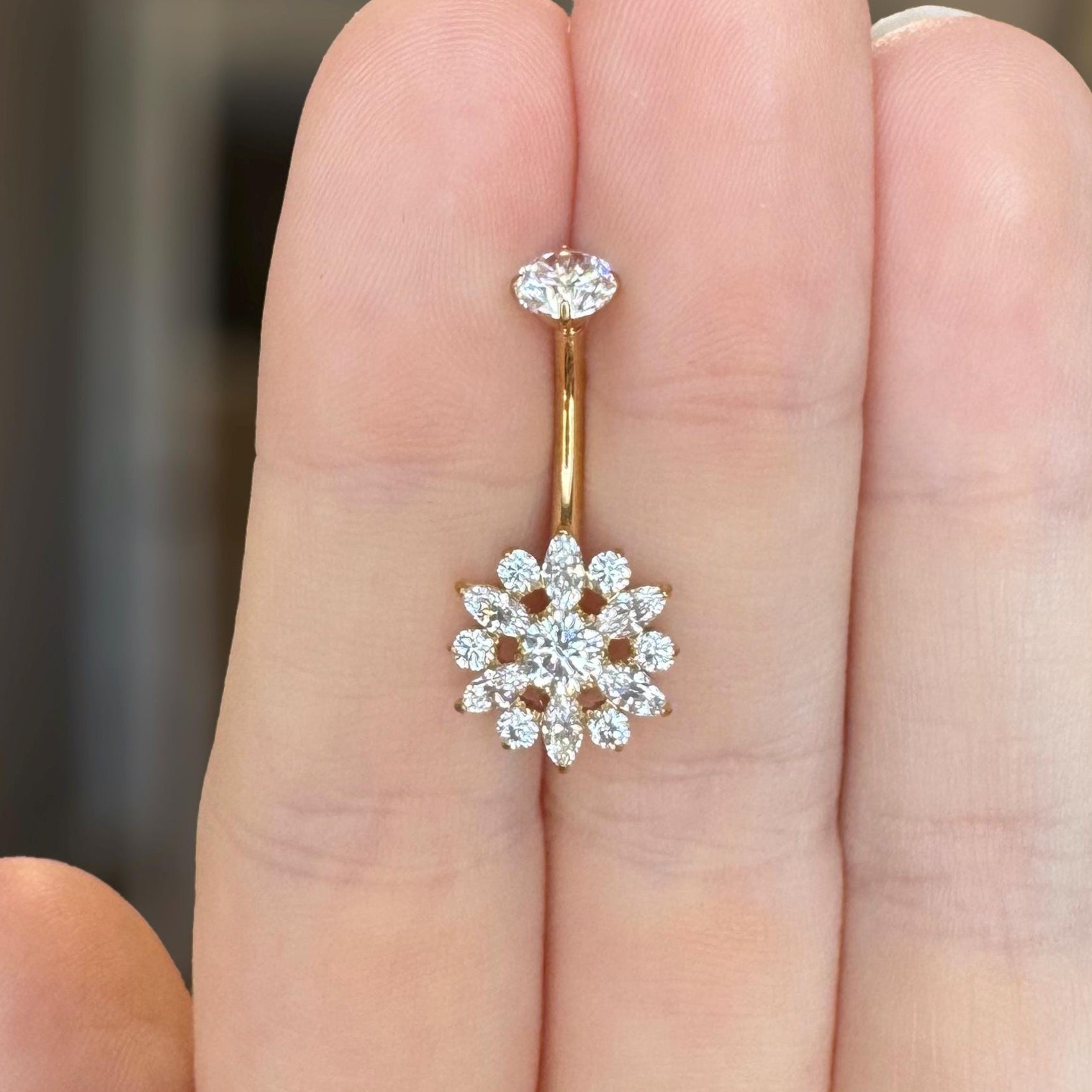Gold belly button ring with a flower CZ design