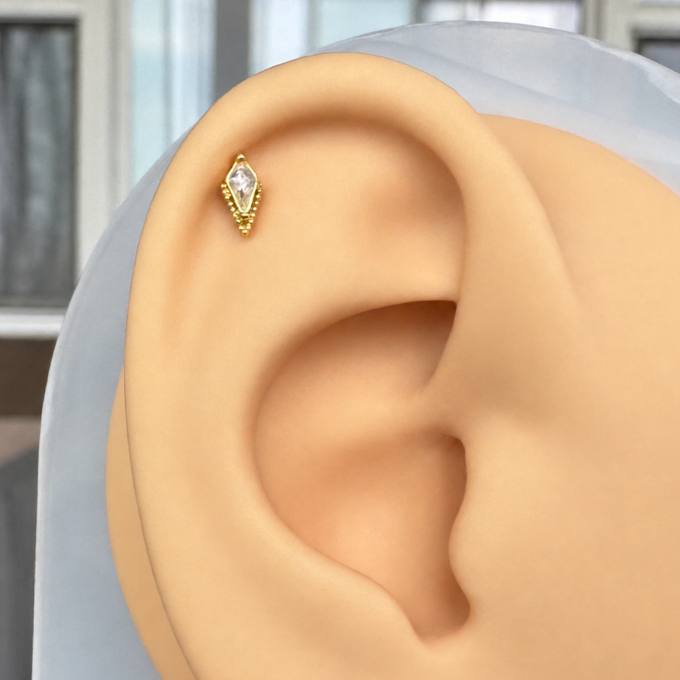 Flat back stud with a kite shaped CZ displayed on a silicone ear