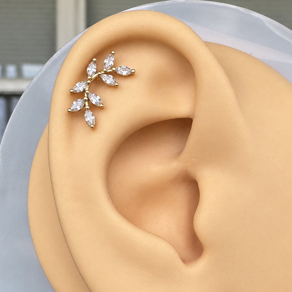 Flat back stud with a branch motif and CZ leaves on a silicone ear for display.