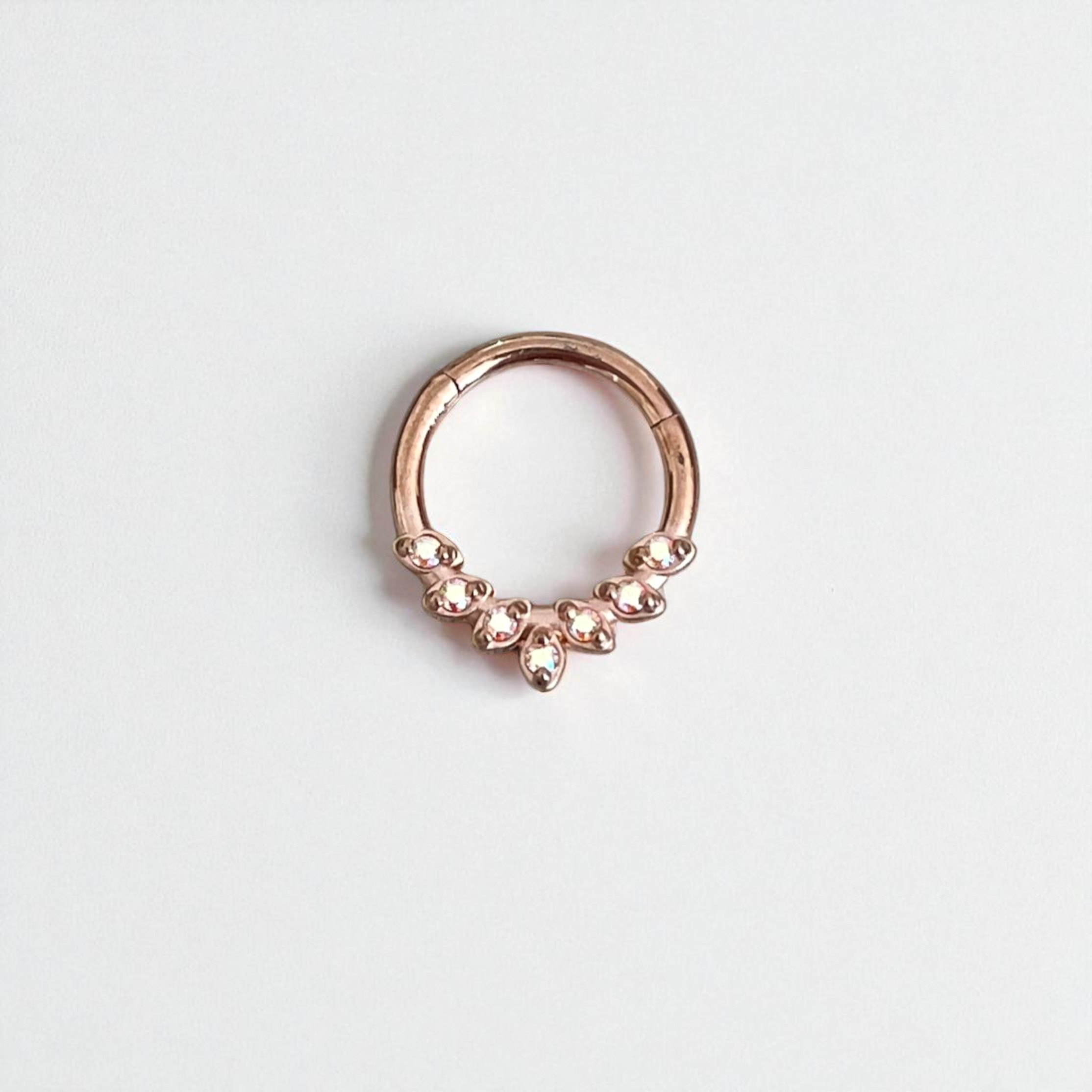 Rose gold sering with small stones on a light gray backgroundtum 