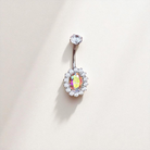 Belly button ring with a colorful gemstone on a light background