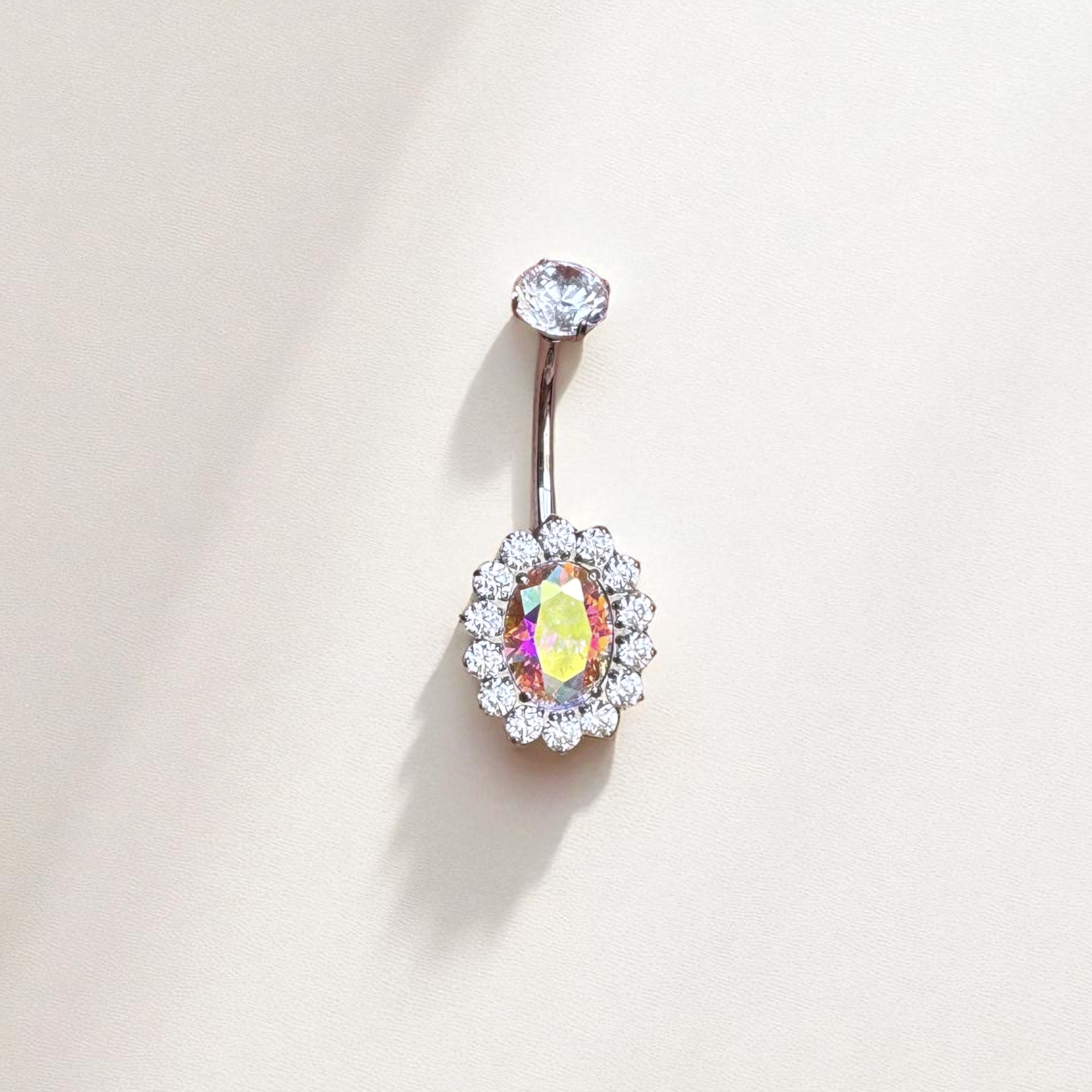 Belly button ring with a colorful gemstone on a light background