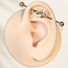 Gold industrial earring with leaf motif on silicone ear