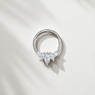 Silver ring with three teardrop-shaped gemstones on a light gray background