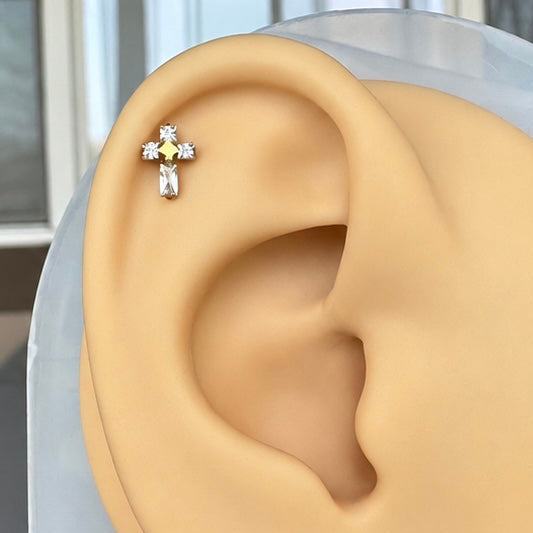 Silicone ear displaying a cross flat back stud with CZs.