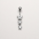 Silver belly button ring with three star-shaped gemstones on a light gray background