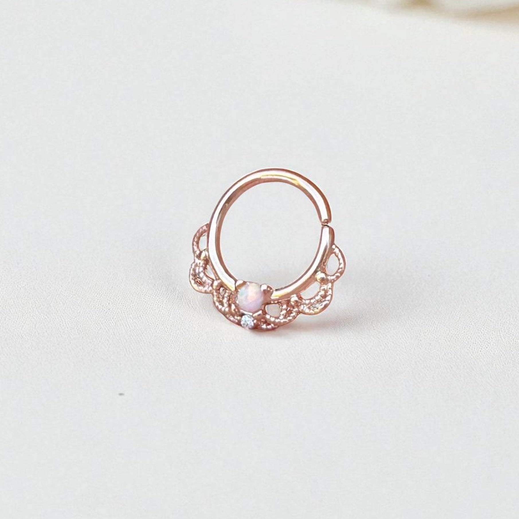 Rose gold ring with a pink opal on a light gray background