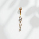 Gold belly button ring with clear marquise gemstones on a white background