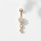 Gold belly button ring with clear gemstones on a white background
