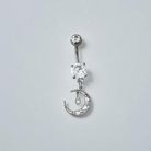 Silver belly button ring with clear gemstones on a light gray background