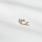 Rose gold earring with floral design on a light gray background