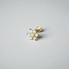 Gold earring with opal stones on a light gray background