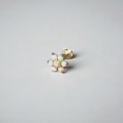 Gold earring with opal stones on a light gray background