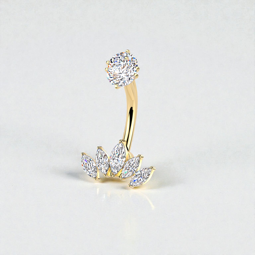 Gold belly button ring with clear gemstones on a light gray background
