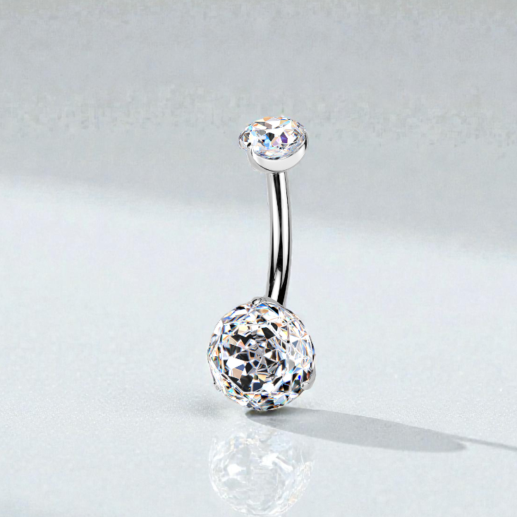 Silver belly button ring with clear gemstones on a light gray background