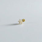 Gold flower flat back earring with clear gemstones on a light gray background