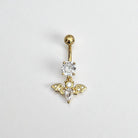 Gold belly button ring with bat design and clear gemstones on a light gray background