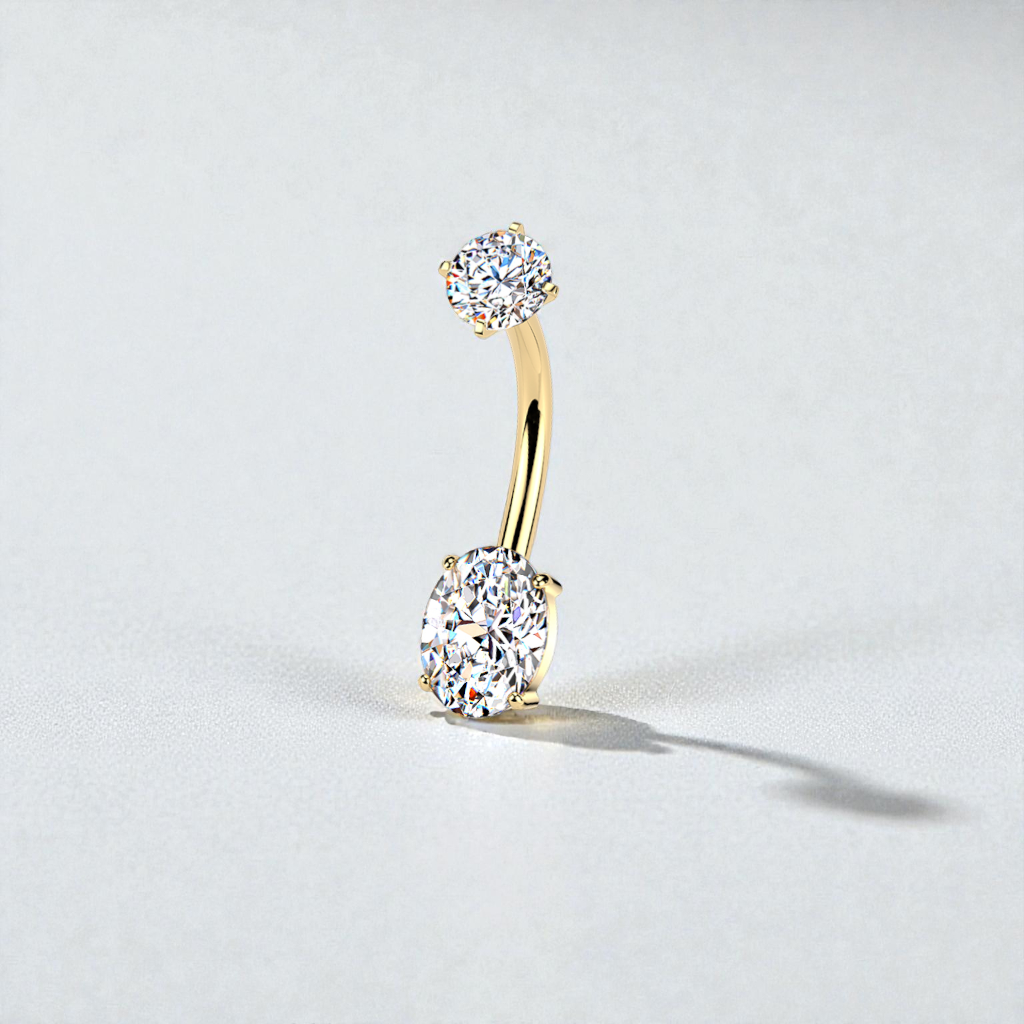Gold belly button ring with clear gemstones on a light gray background