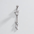Butterfly-shaped belly button ring with dangling crystals on a light gray background