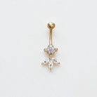 Gold belly button ring with gemstones on a light gray background